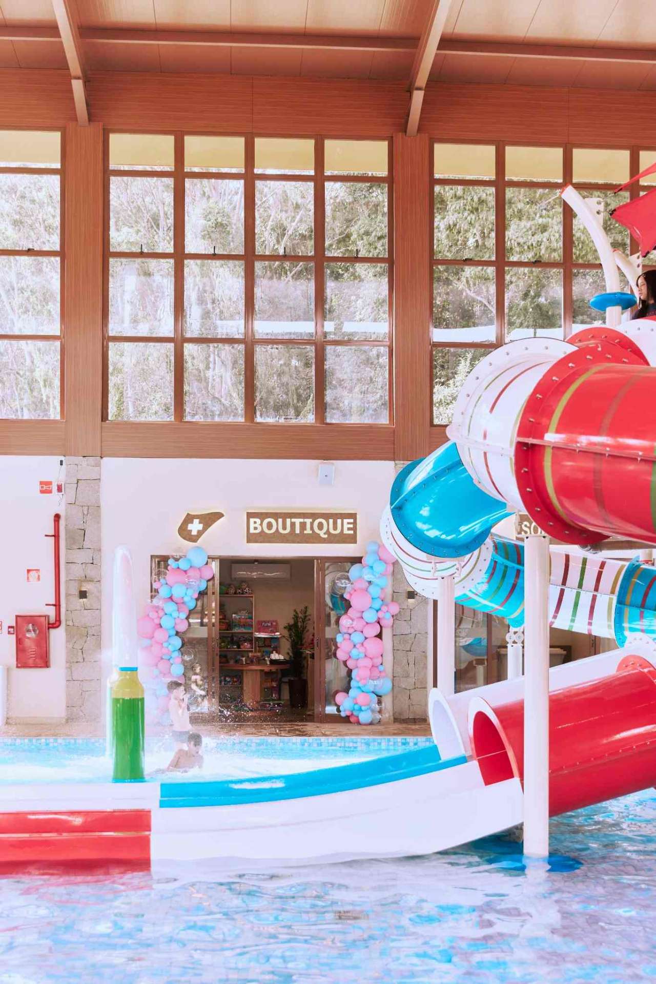 Piscina e toboáguas com o letreiro Le Canton Alpenmare ao fundo