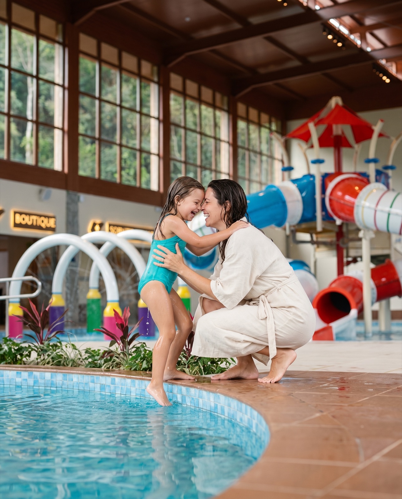 Mãe e filha abraçadas à beira da piscina
