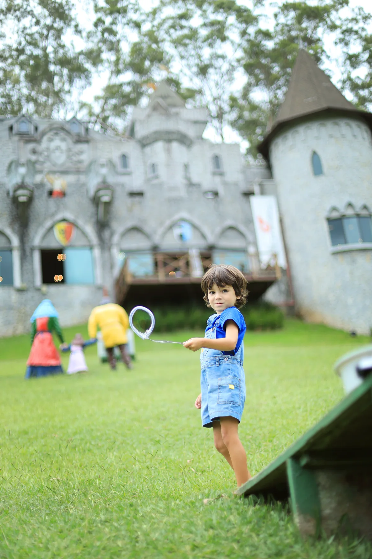 Criança brincando no gramado em frente ao Castelo