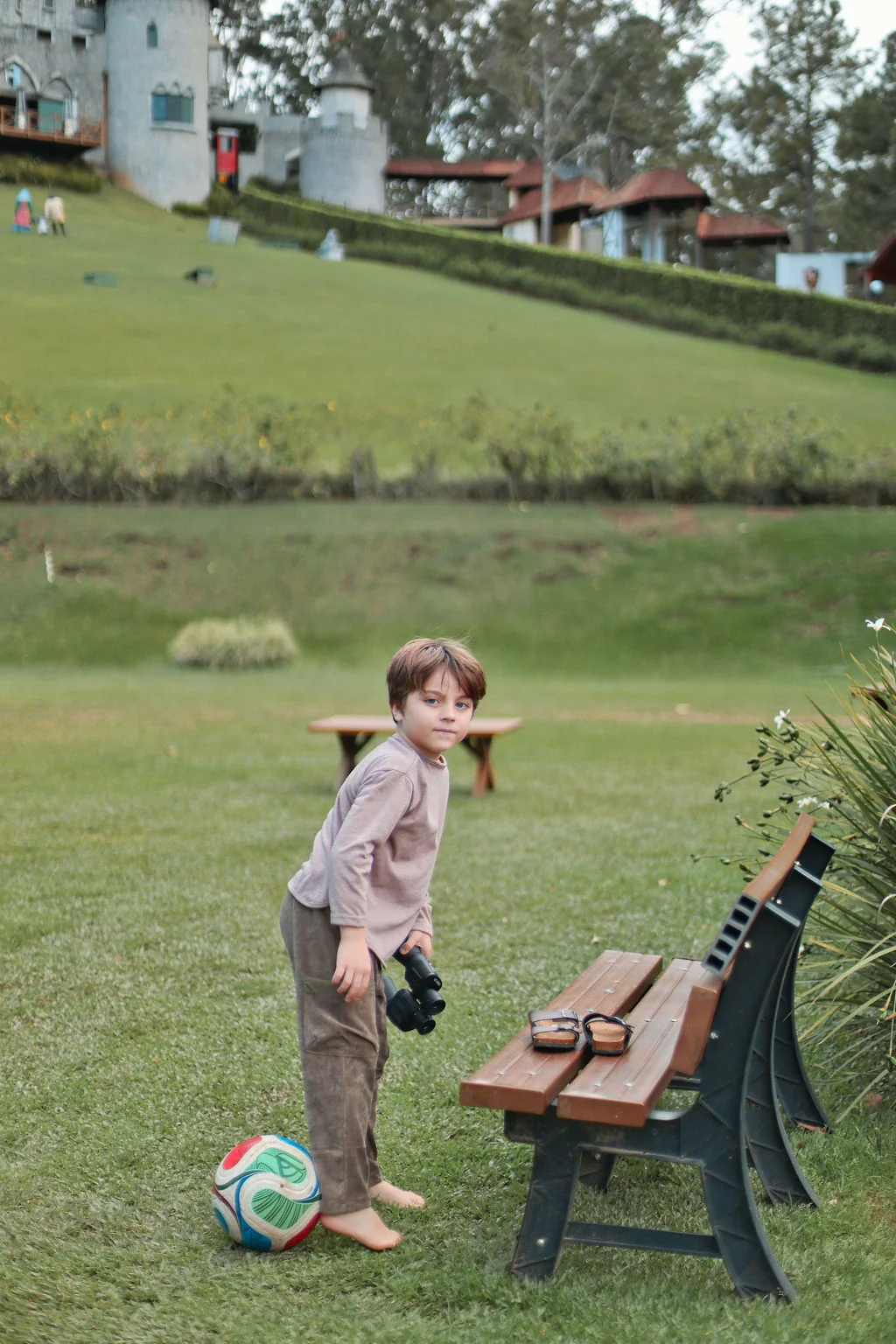 Crian&ccedil;a brincando com bola nos jardins do Le Canton